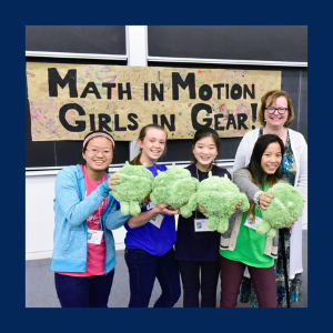 Girls holding a plush toy. Event photo of math in motion