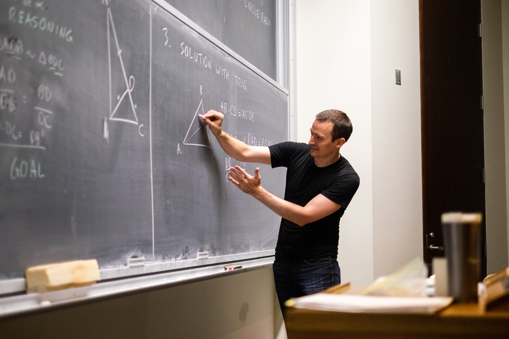 Post-doc Zack Wolske draws math problems on the blackboard at the Bahen Centre
