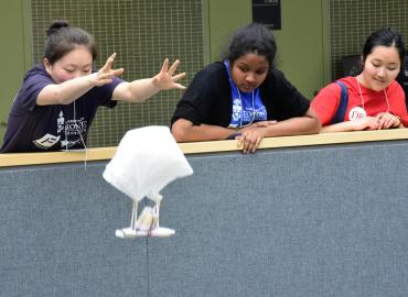 Youth students experimenting with a parachute at a math event